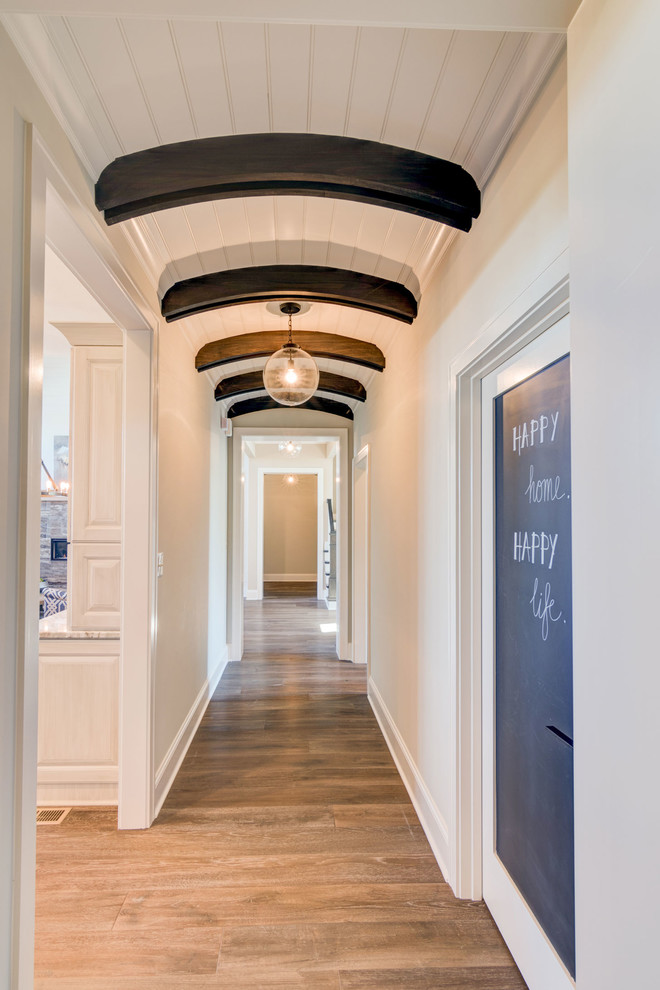 Photo of a modern hallway in Indianapolis with white walls and medium hardwood floors.