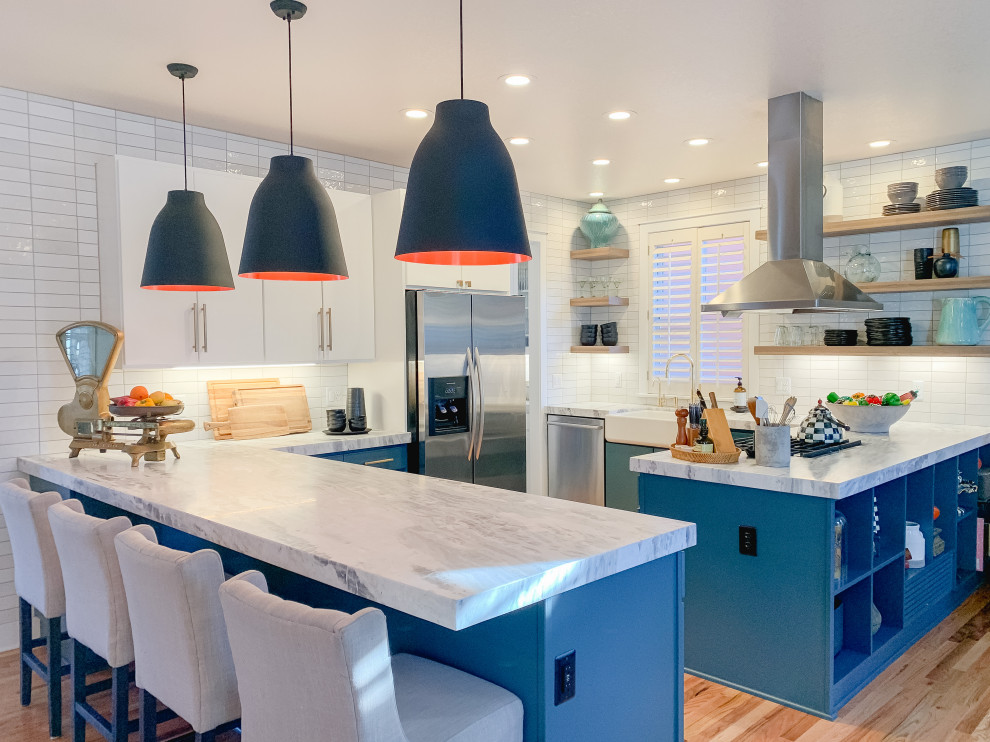 Photo of a mid-sized transitional u-shaped eat-in kitchen in Denver with an undermount sink, flat-panel cabinets, turquoise cabinets, quartzite benchtops, white splashback, ceramic splashback, stainless steel appliances, medium hardwood floors, a peninsula and grey benchtop.