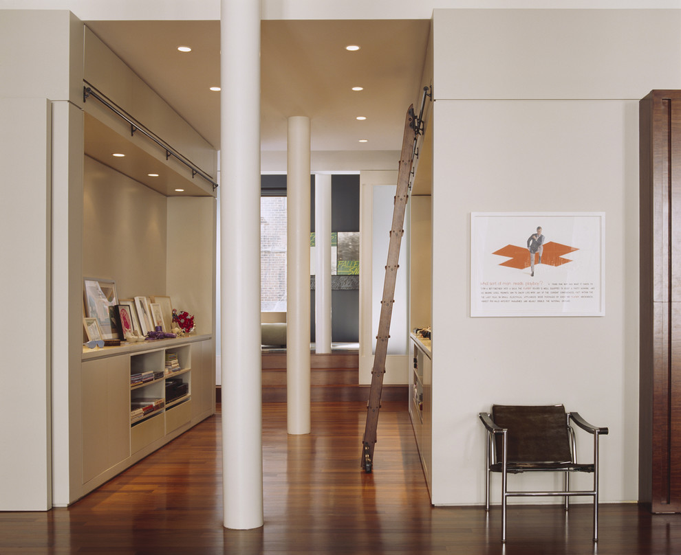 Inspiration for an expansive contemporary entryway in New York with white walls and dark hardwood floors.