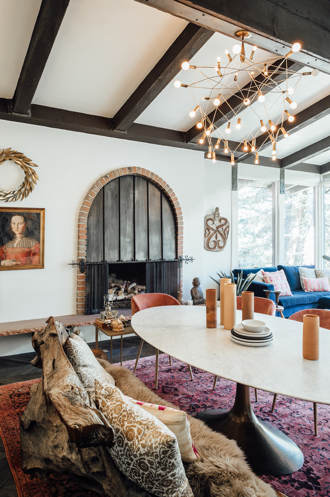 This is an example of a large eclectic open concept living room in Salt Lake City with white walls, dark hardwood floors, a standard fireplace, a brick fireplace surround, no tv and black floor.