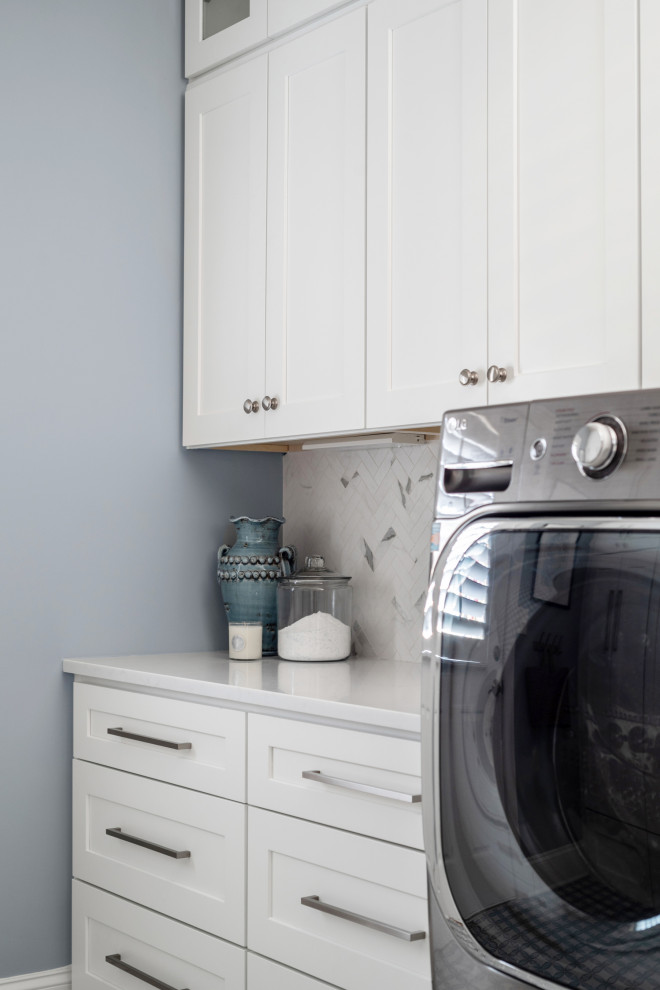Foto på en liten vintage vita parallell tvättstuga enbart för tvätt, med skåp i shakerstil, vita skåp, bänkskiva i kvarts, vitt stänkskydd, stänkskydd i marmor, blå väggar, klinkergolv i porslin, en tvättmaskin och torktumlare bredvid varandra och blått golv