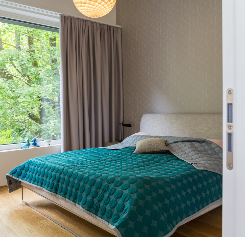 Modernes Schlafzimmer mit grauer Wandfarbe, Tapetenwänden und braunem Holzboden in München