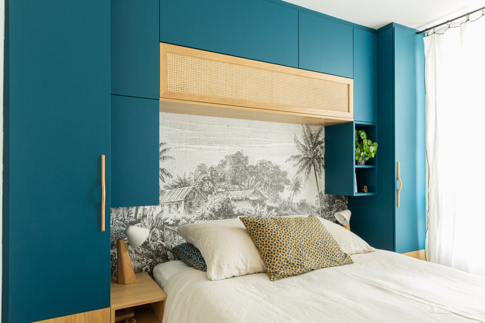 Kleines Hauptschlafzimmer mit blauer Wandfarbe, hellem Holzboden, beigem Boden und Tapetenwänden in Paris