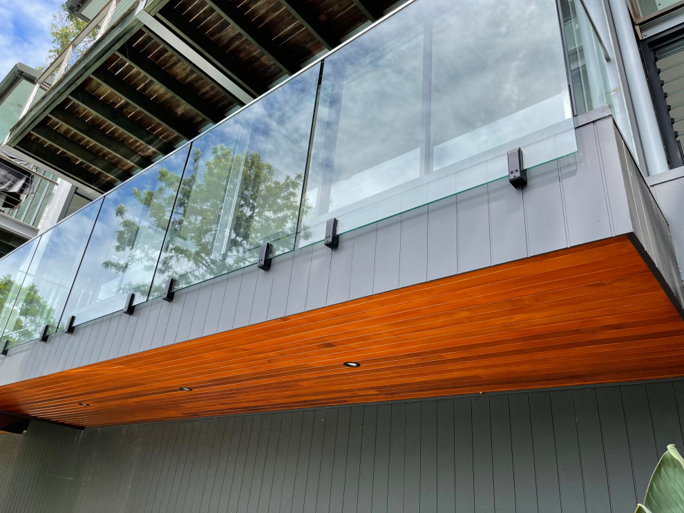 Réalisation d'un balcon minimaliste de taille moyenne avec un garde-corps en matériaux mixtes.