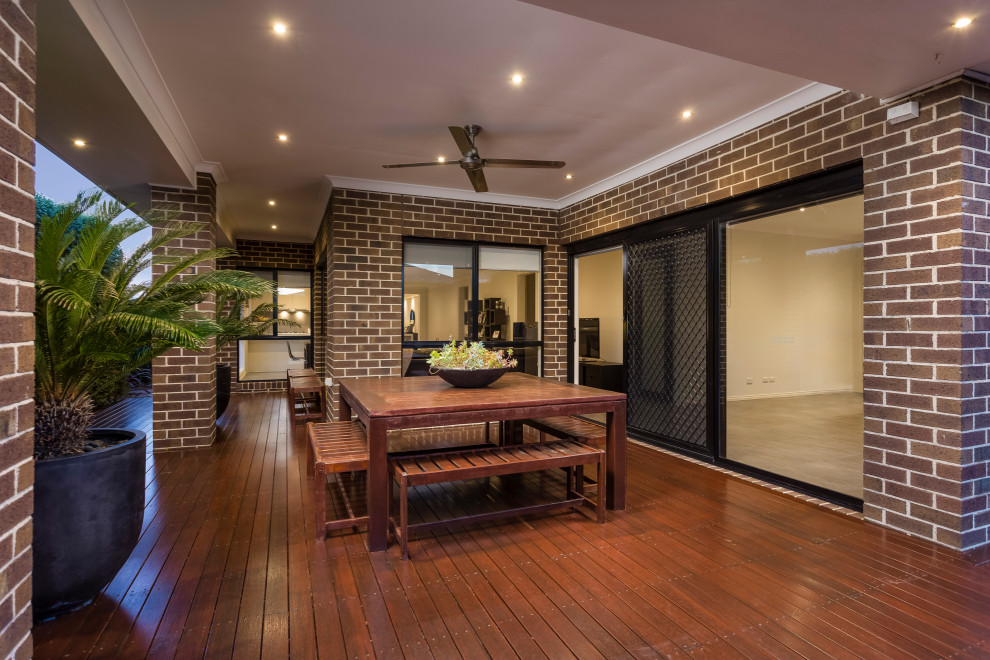 Design ideas for a mid-sized contemporary backyard deck in Melbourne with with dock and a roof extension.
