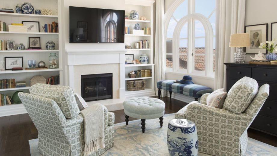Inspiration for a mid-sized beach style open concept family room in Los Angeles with beige walls, dark hardwood floors, a standard fireplace, a plaster fireplace surround and a wall-mounted tv.