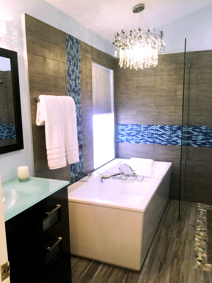 Aménagement d'une salle de bain moderne avec un carrelage bleu et des plaques de verre.