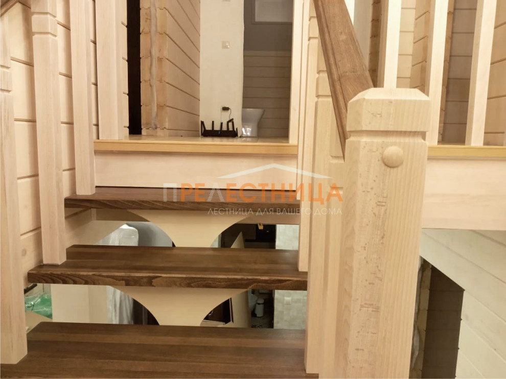 На фото: п-образная металлическая лестница среднего размера с крашенными деревянными ступенями, деревянными перилами и деревянными стенами