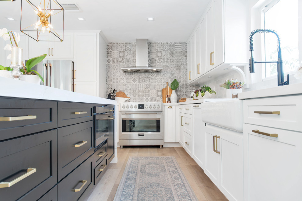 Inspiration for a mid-sized transitional l-shaped open concept kitchen remodel in Miami with shaker cabinets, white cabinets, quartz countertops, gray backsplash, porcelain backsplash, stainless steel appliances, an island and white countertops