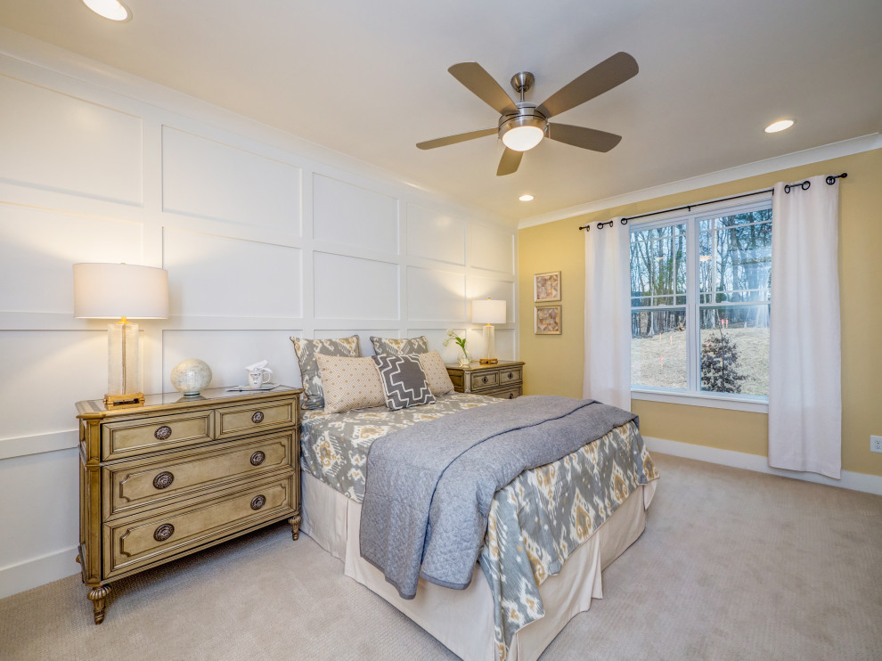 Photo of a large bedroom in Charlotte with yellow walls, carpet, beige floor and panelled walls.