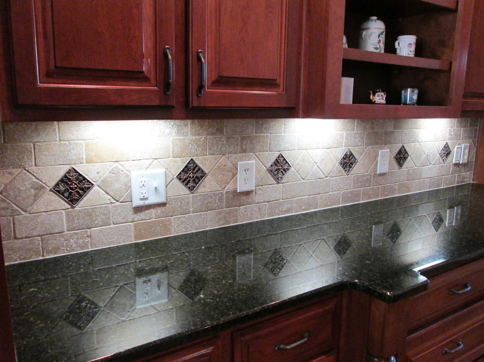 Inspiration for a modern galley enclosed kitchen remodel in Atlanta with raised-panel cabinets, granite countertops, brown backsplash, stone tile backsplash, an integrated sink, dark wood cabinets and black appliances