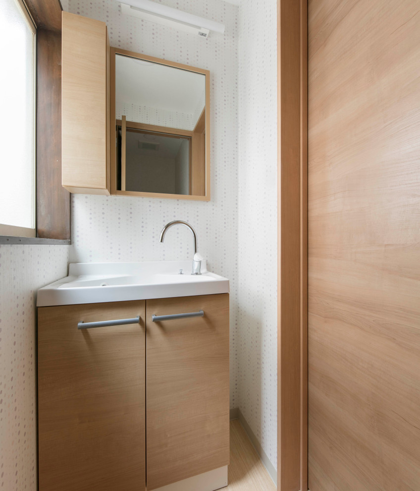 Idéer för att renovera ett litet skandinaviskt vit vitt toalett, med luckor med profilerade fronter, skåp i mellenmörkt trä, vit kakel, vita väggar, klinkergolv i småsten, ett integrerad handfat, bänkskiva i akrylsten och beiget golv