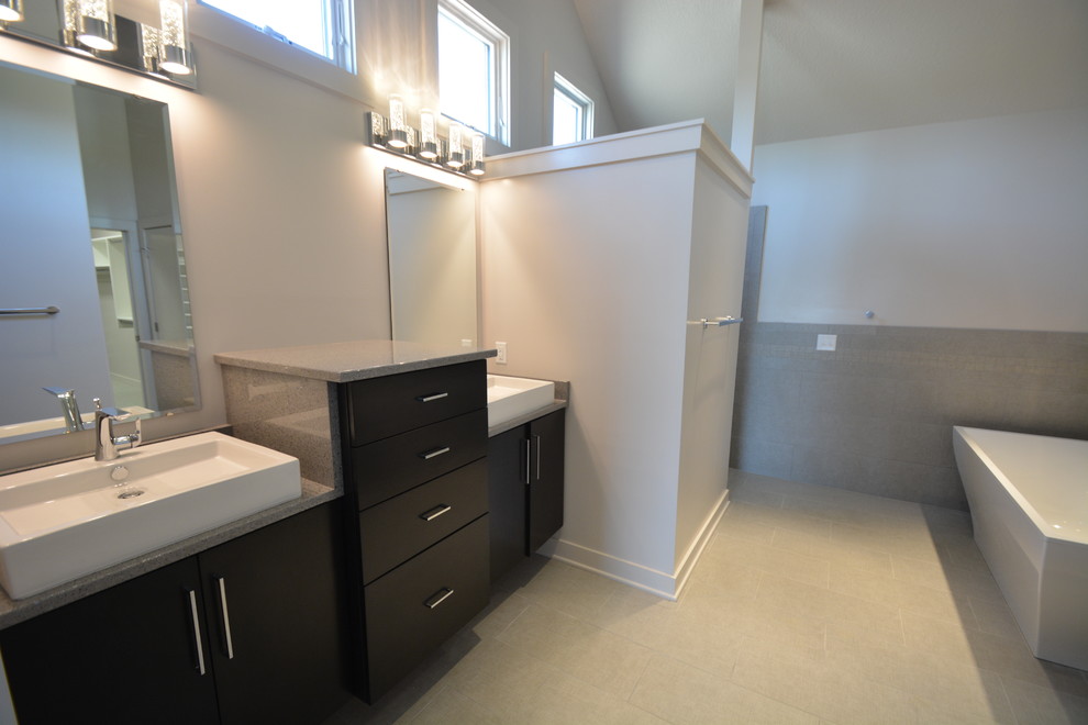 Inspiration for a mid-sized contemporary master bathroom in Other with flat-panel cabinets, dark wood cabinets, a freestanding tub, an open shower, a one-piece toilet, gray tile, stone slab, white walls, ceramic floors, a vessel sink and granite benchtops.