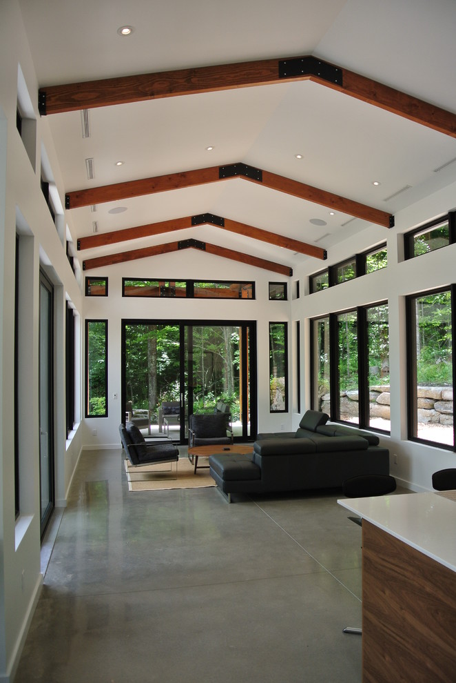 Mid-sized modern open concept living room in Montreal with white walls and concrete floors.