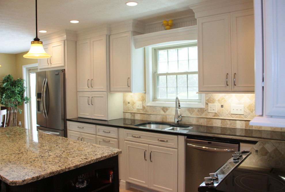 Inspiration for a large transitional u-shaped medium tone wood floor kitchen remodel in Cincinnati with an undermount sink, recessed-panel cabinets, white cabinets, granite countertops, beige backsplash, stone tile backsplash, stainless steel appliances and an island