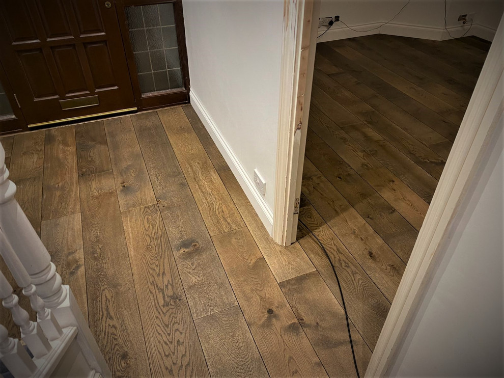 Example of a mid-sized classic medium tone wood floor and brown floor hallway design in Hertfordshire with white walls