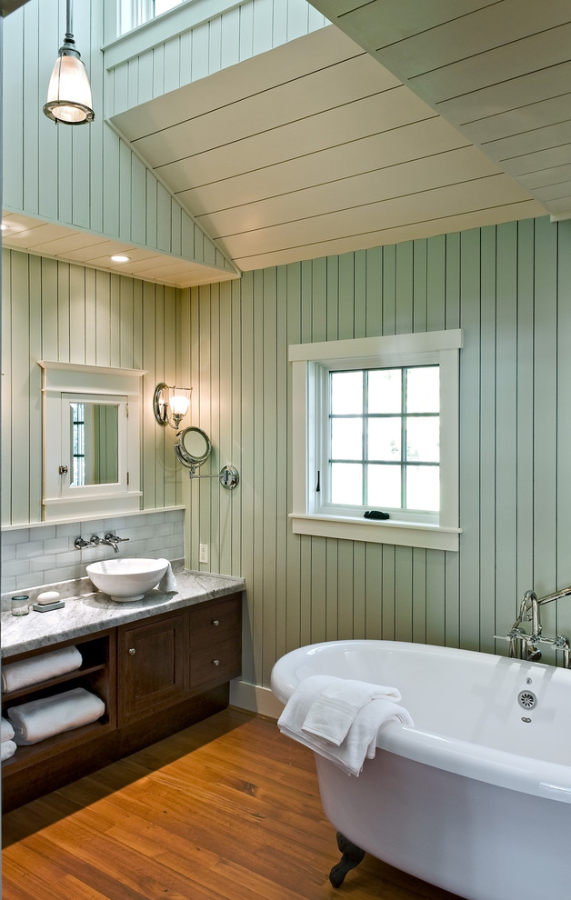 Photo of a beach style bathroom in Portland Maine with a claw-foot tub, a vessel sink and green walls.