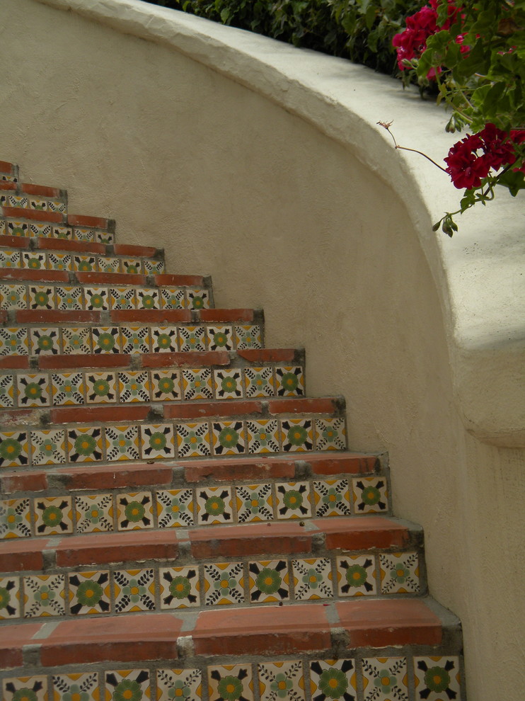 Gewendelte Mediterrane Treppe mit Terrakotta-Treppenstufen und gefliesten Setzstufen in Santa Barbara
