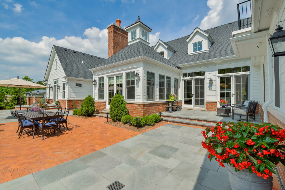 Foto di un ampio patio o portico classico in cortile con pavimentazioni in mattoni e una pergola