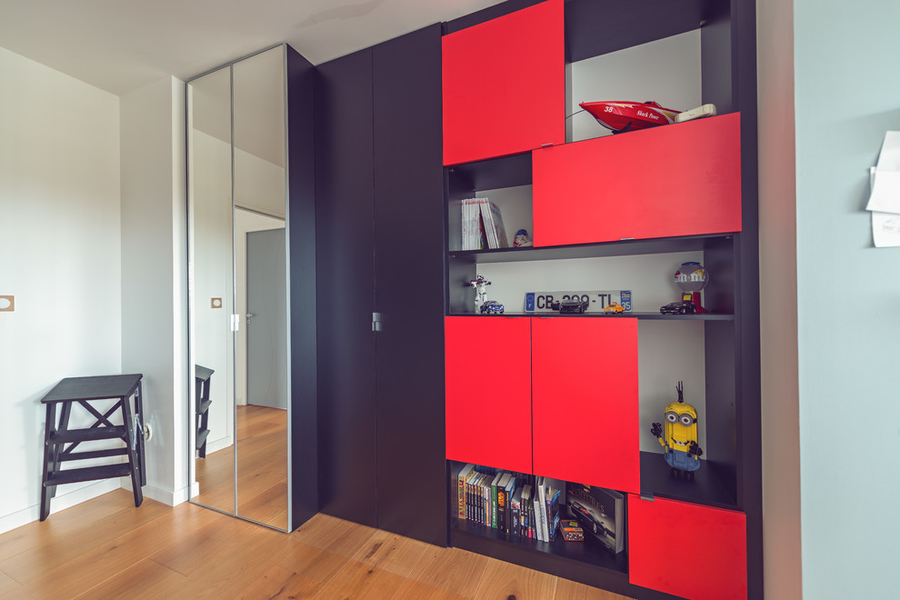 Mid-sized contemporary men's built-in wardrobe in Rennes with beaded inset cabinets, black cabinets and light hardwood floors.