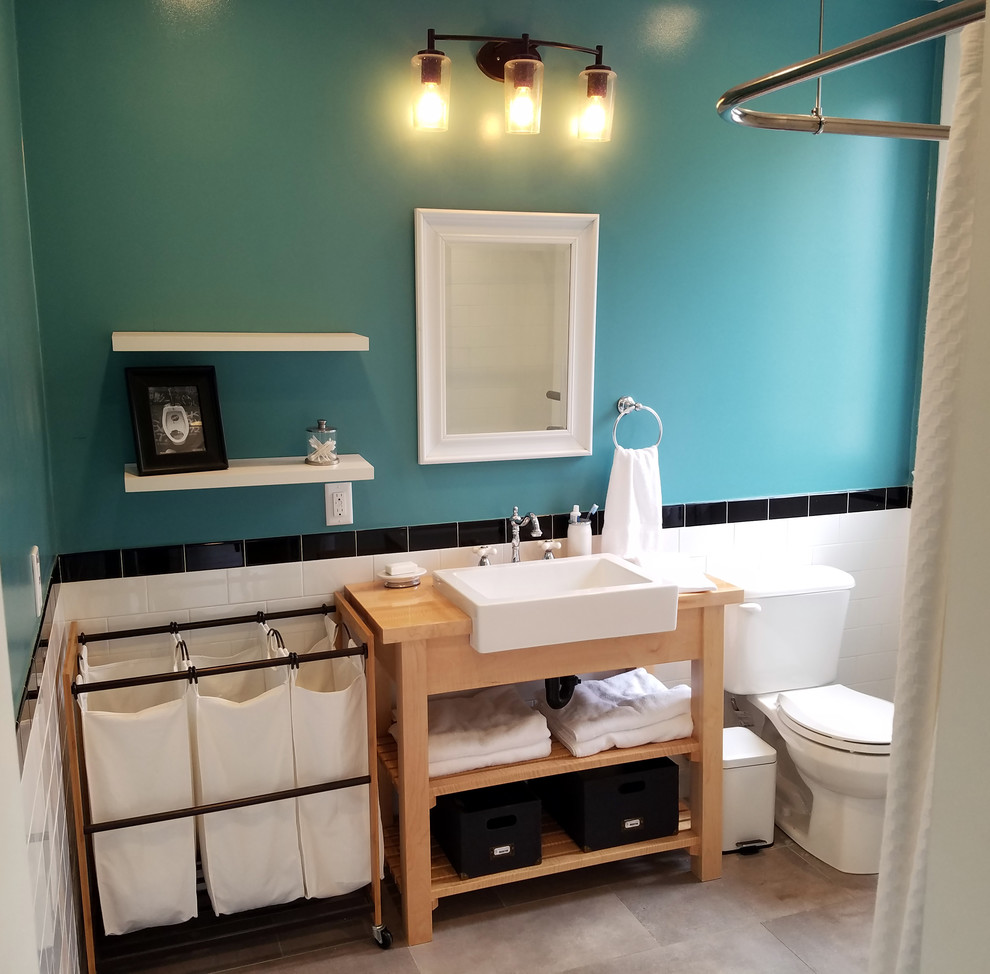 Photo of a small eclectic 3/4 bathroom in Los Angeles with open cabinets, light wood cabinets, an open shower, a two-piece toilet, white tile, porcelain tile, blue walls, porcelain floors, a drop-in sink and wood benchtops.