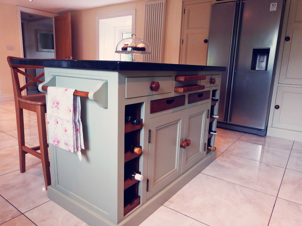 Photo of a farmhouse u-shaped kitchen in Belfast with beige cabinets, wood worktops and an island.