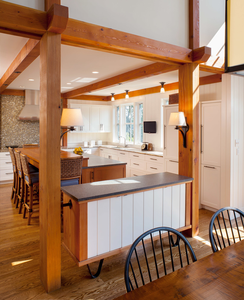Design ideas for a mid-sized country l-shaped eat-in kitchen in Providence with recessed-panel cabinets, white cabinets, soapstone benchtops, panelled appliances, medium hardwood floors and with island.