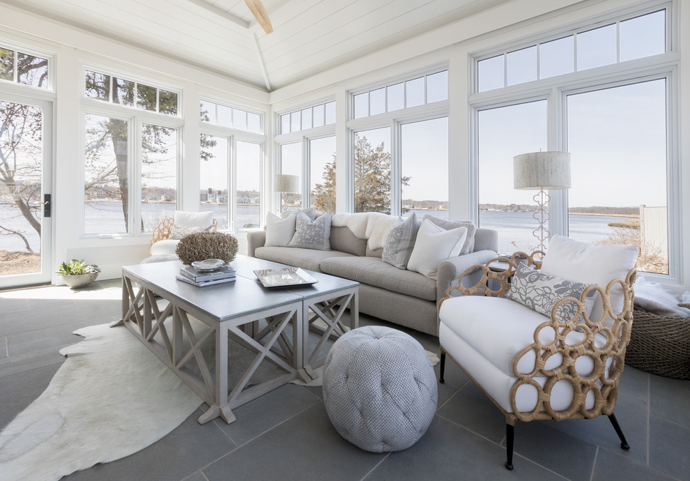 Photo of a large beach style sunroom in Boston with a skylight, grey floor, slate floors, a standard fireplace and a stone fireplace surround.