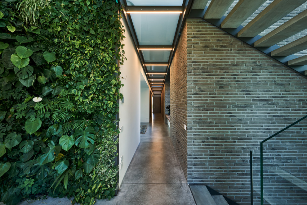 Ispirazione per un ingresso o corridoio minimalista con pavimento in cemento
