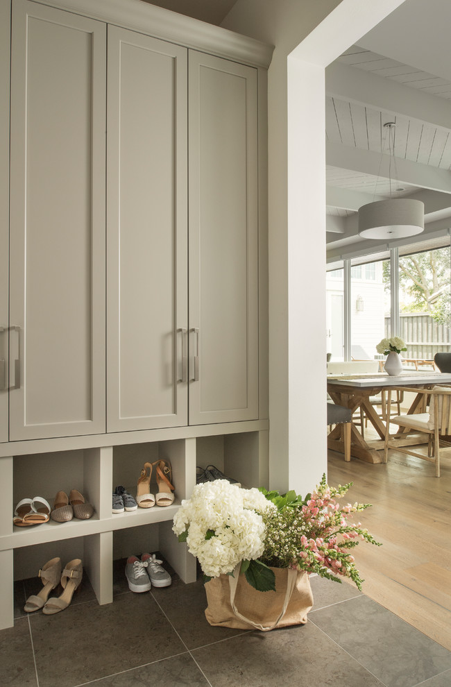 Design ideas for a transitional mudroom in Orlando with white walls and grey floor.
