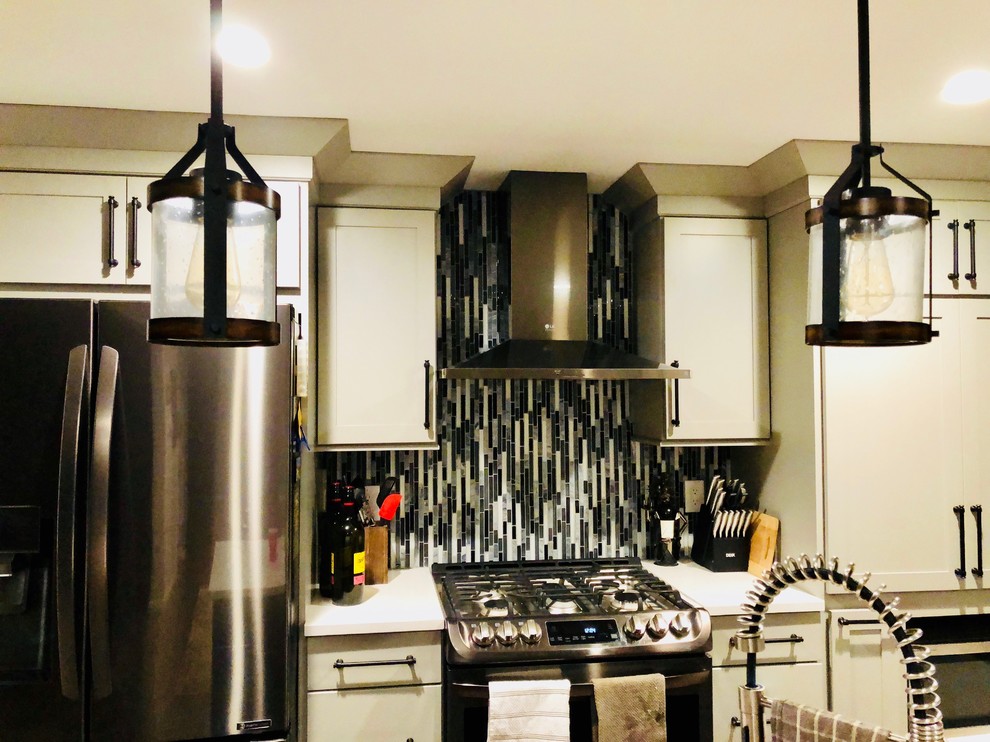 Inspiration for a mid-sized transitional bamboo floor and brown floor eat-in kitchen remodel with a farmhouse sink, shaker cabinets, gray cabinets, quartz countertops, multicolored backsplash, mosaic tile backsplash, stainless steel appliances, an island and white countertops