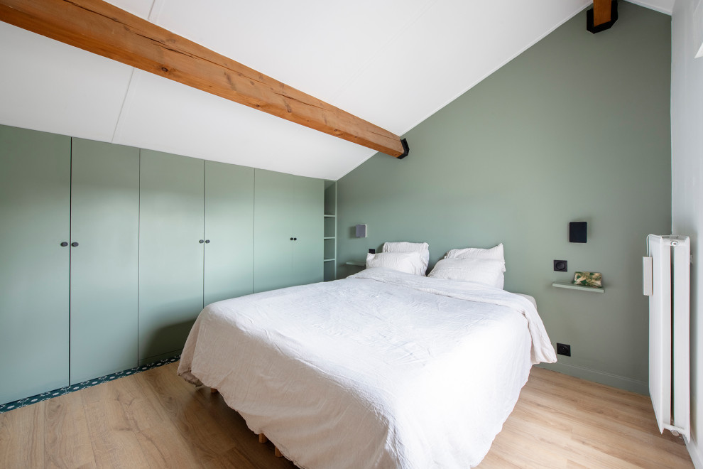 Bild på ett mellanstort skandinaviskt sovloft, med gröna väggar, ljust trägolv och beiget golv