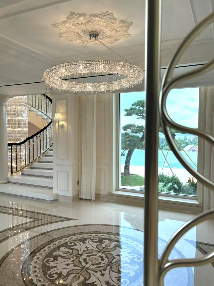 Huge transitional marble floor, multicolored floor, coffered ceiling and shiplap wall entry hall photo with white walls and a black front door