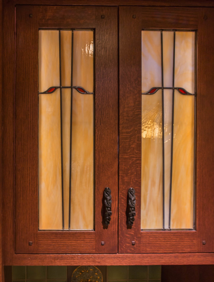 Example of a transitional kitchen design in Denver with glass-front cabinets and dark wood cabinets