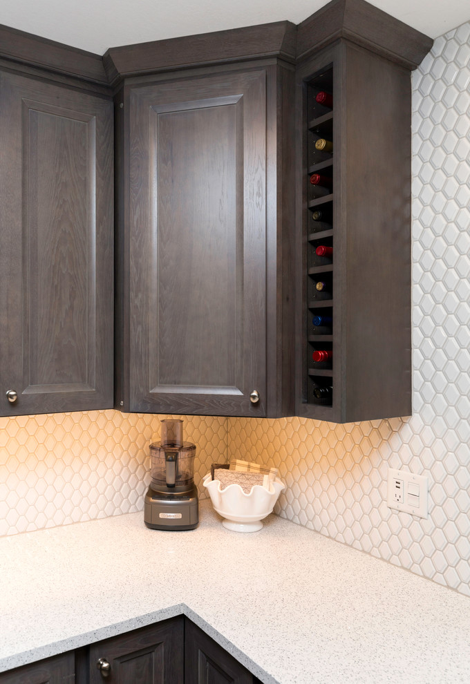 Mid-sized transitional l-shaped vinyl floor and gray floor eat-in kitchen photo with a farmhouse sink, recessed-panel cabinets, gray cabinets, quartz countertops, white backsplash, ceramic backsplash, stainless steel appliances, no island and white countertops