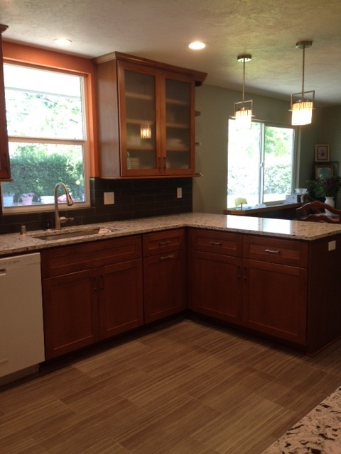 Example of a transitional porcelain tile kitchen design in Seattle with an undermount sink, shaker cabinets, medium tone wood cabinets, quartz countertops, gray backsplash, glass tile backsplash and white appliances