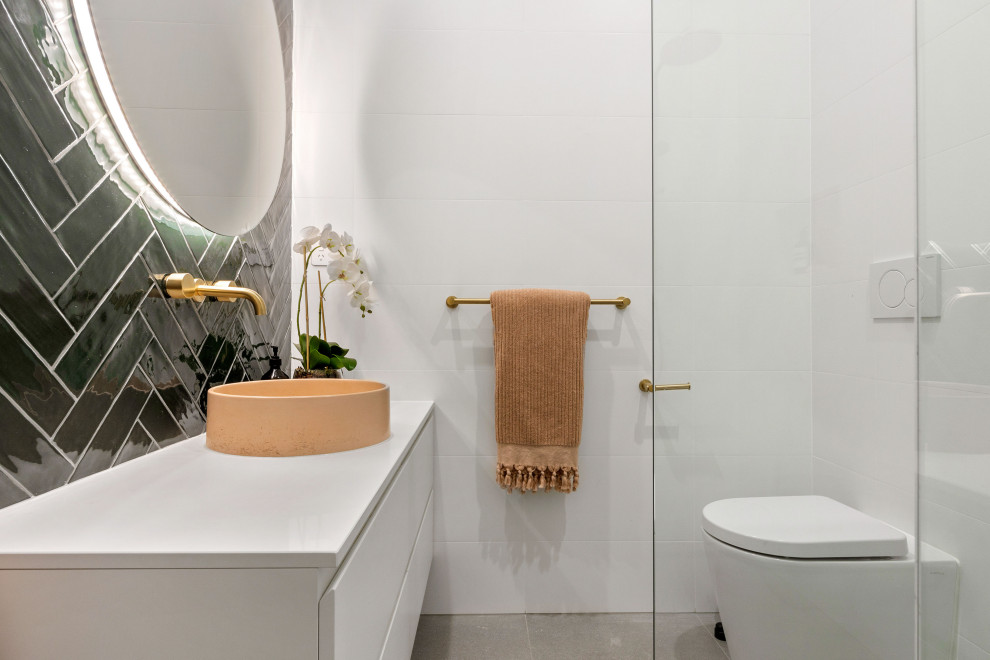 Inspiration for a mid-sized contemporary powder room in Melbourne with white cabinets, white tile, porcelain tile, green walls, porcelain floors, a vessel sink, engineered quartz benchtops, grey floor, white benchtops and a floating vanity.