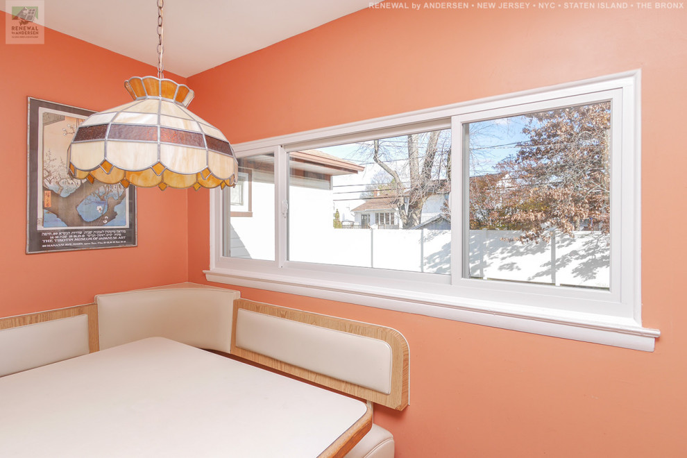 На фото: кухня-столовая среднего размера с оранжевыми стенами, полом из керамической плитки и белым полом без камина