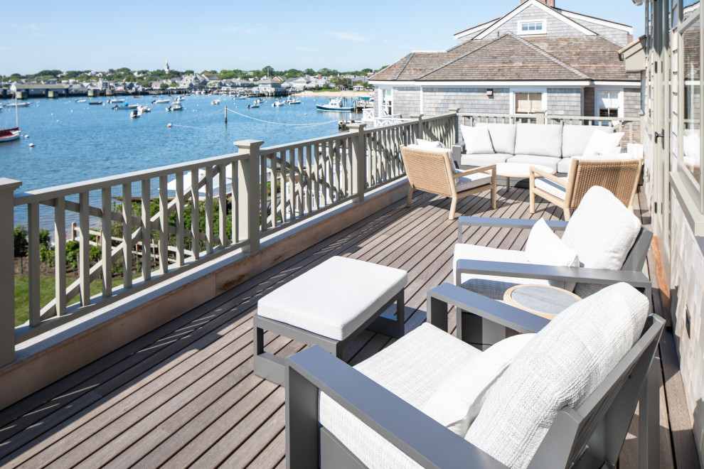 Design ideas for a mid-sized beach style backyard and first floor deck with no cover and metal railing.