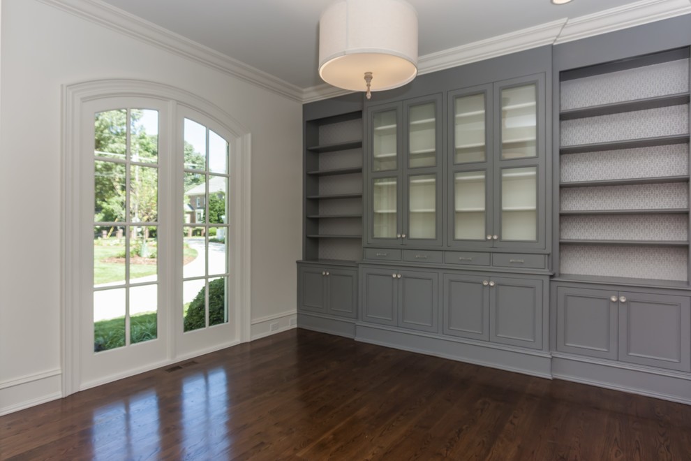 This is an example of a transitional study room in Raleigh with white walls and dark hardwood floors.