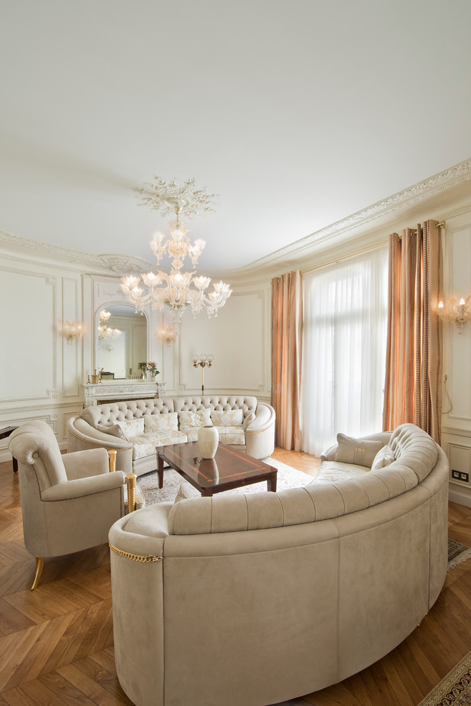This is an example of a large transitional family room in Paris with beige walls, medium hardwood floors, a standard fireplace and no tv.