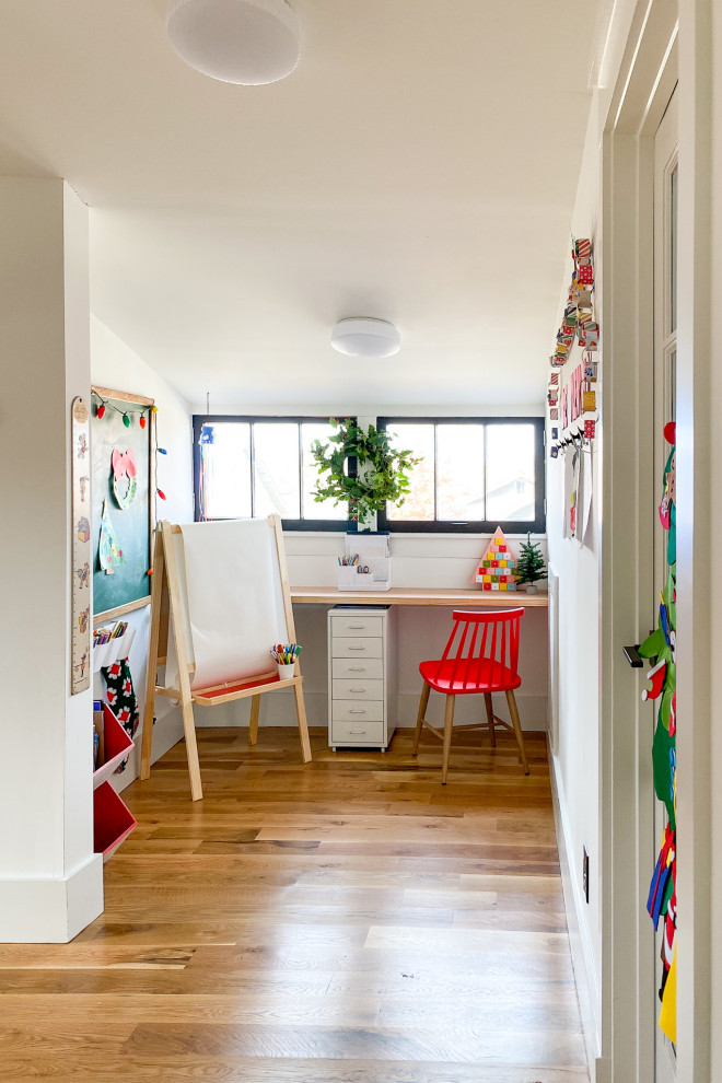 Inspiration för ett litet funkis barnrum kombinerat med skrivbord och för 4-10-åringar, med vita väggar, ljust trägolv och brunt golv