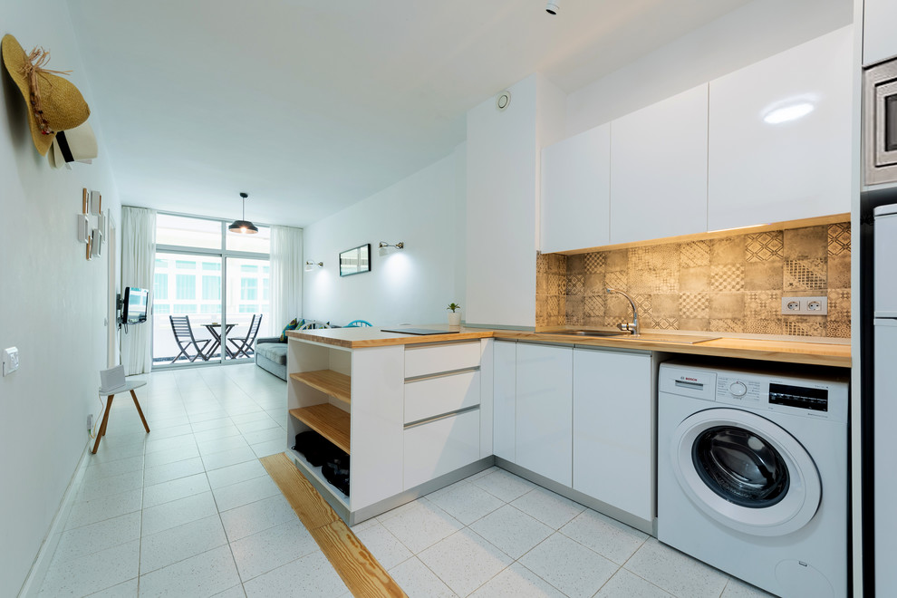 Imagen de cocinas en L escandinava pequeña abierta con puertas de armario blancas y encimera de madera