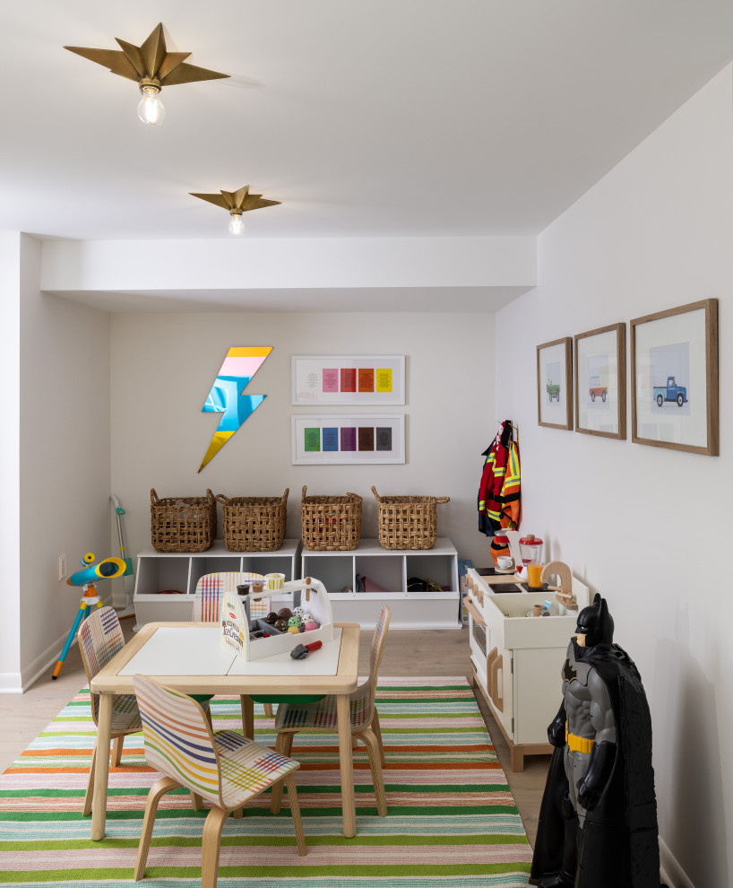 Photo of a mid-sized transitional gender-neutral kids' playroom in Detroit with white walls and brown floor.