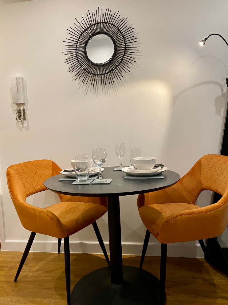 Idées déco pour une petite salle à manger contemporaine avec un mur bleu, sol en stratifié et un sol orange.