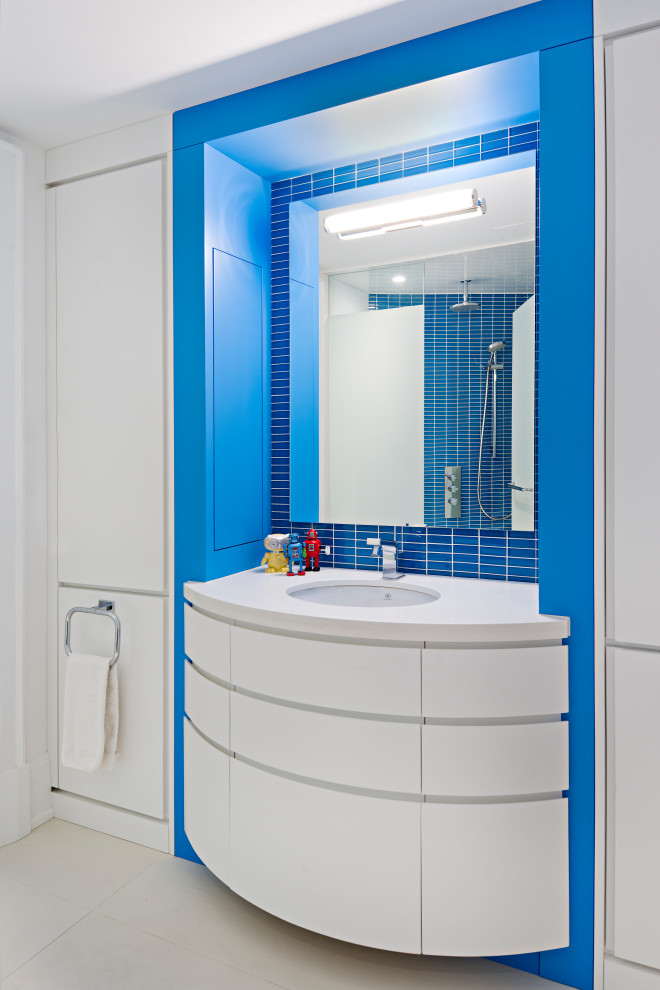 Идея дизайна: большая детская ванная комната в современном стиле с плоскими фасадами, белыми фасадами, синей плиткой, стеклянной плиткой, белыми стенами, мраморным полом, врезной раковиной, столешницей из кварцита, белым полом, белой столешницей, тумбой под одну раковину, подвесной тумбой и многоуровневым потолком