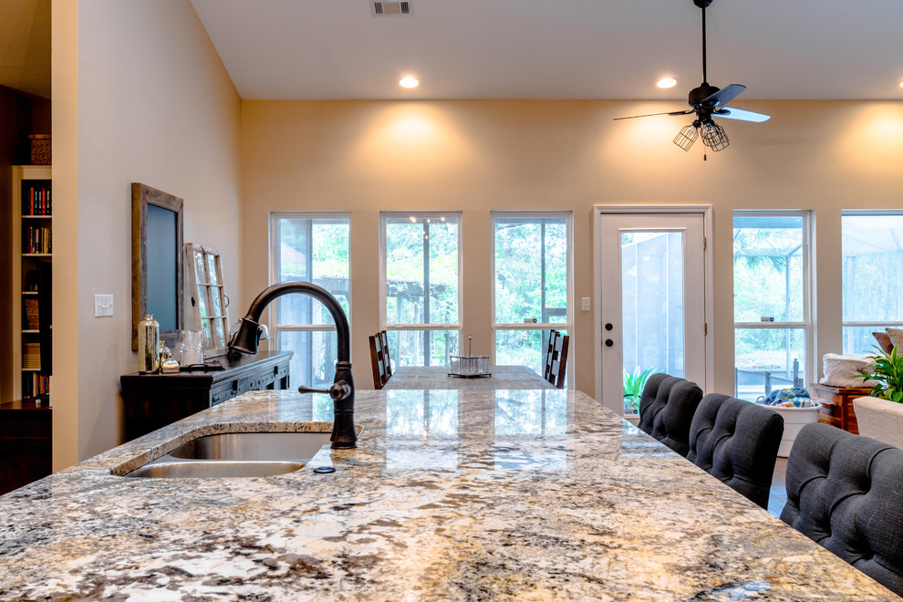 Large transitional l-shaped vinyl floor eat-in kitchen photo in Miami with an undermount sink, shaker cabinets, dark wood cabinets, granite countertops, beige backsplash, porcelain backsplash, stainless steel appliances and an island