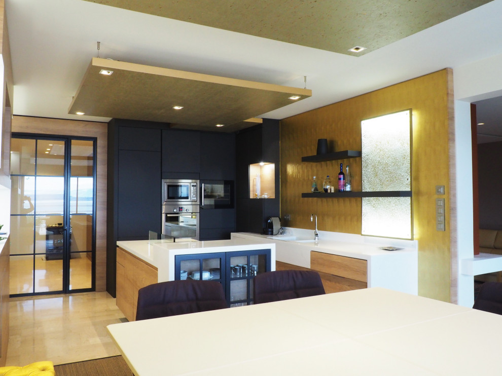 Design ideas for a large transitional l-shaped eat-in kitchen in Other with an integrated sink, flat-panel cabinets, grey cabinets, solid surface benchtops, yellow splashback, stainless steel appliances, travertine floors, with island, beige floor, white benchtop and recessed.
