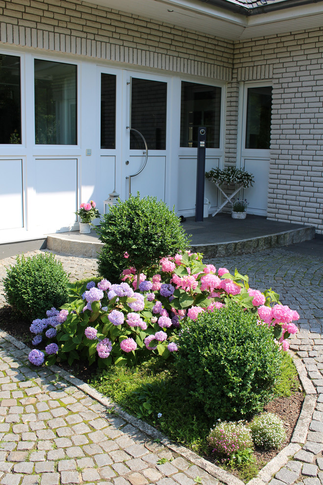 Große Country Gartenmauer im Sommer mit Natursteinplatten und direkter Sonneneinstrahlung in Hamburg