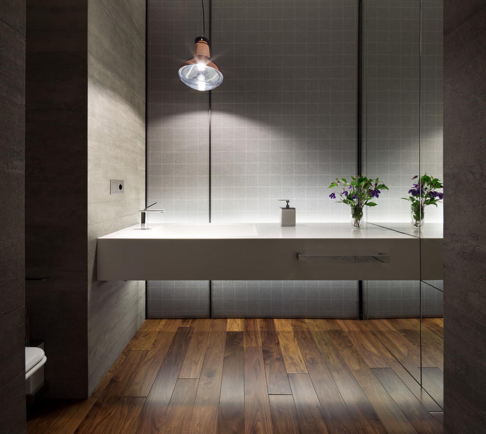 Inspiration for a contemporary powder room in Other with an integrated sink, grey walls and dark hardwood floors.